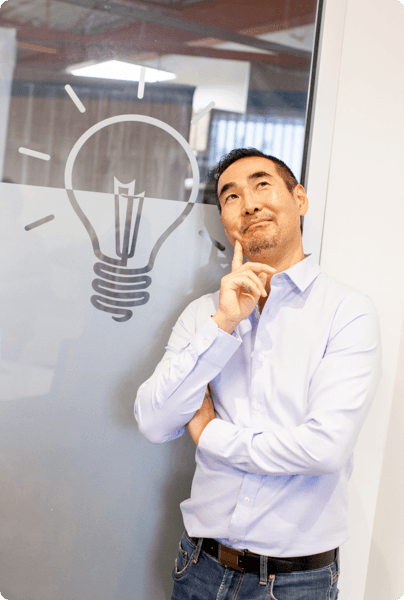 employee posing with thinking face in front graphic of lightbulb - "great ideas"