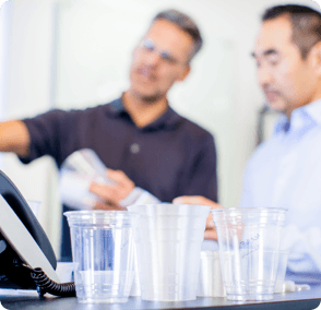 R&D, workers in office with several empty clear cups in front of them