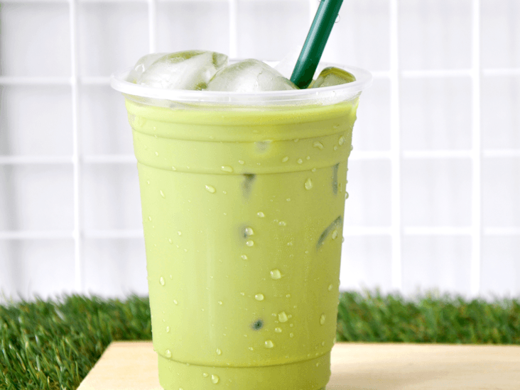 green tea smoothie in clear cup with green straw