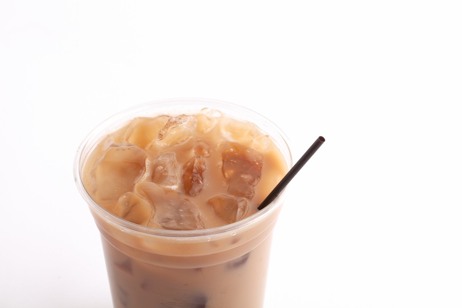 closeup of iced coffee in clear cup with coffee stirrer